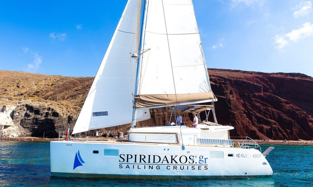 Sailing past the Red beach, one of the main reasons to go on a sailing cruise in Santorini