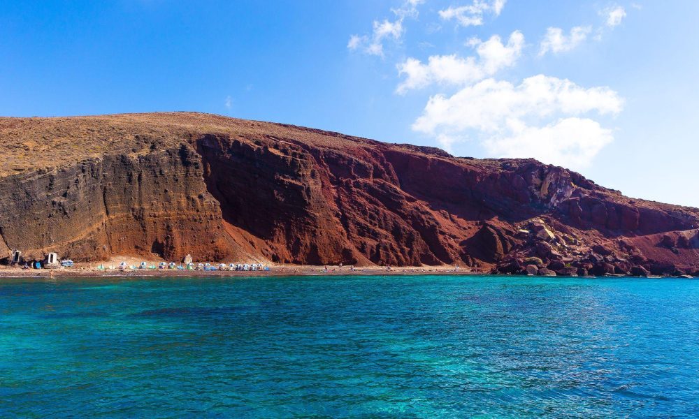 The famous Red Beach as seen from a Santorini Greece cruise with Spiridakos Sailing Cruises. Explore the island from a unique vantage point, away from the crowds.