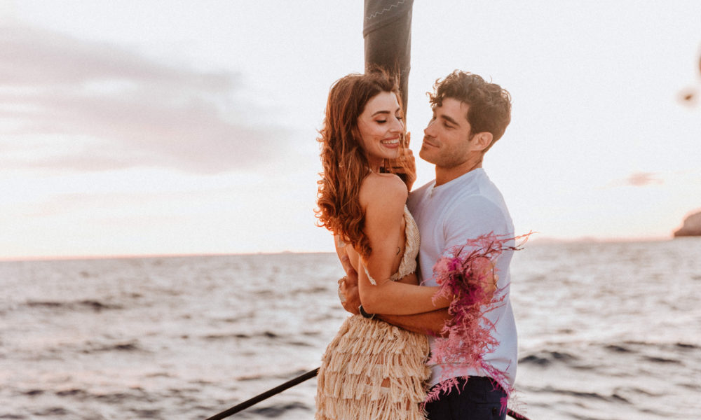 Happy couple after their Santorini proposal at sea on board a catamaran with Spiridakos Sailing Cruises
