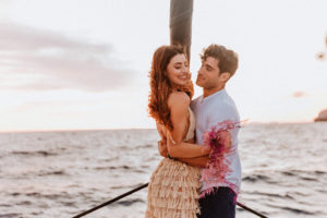 Happy couple after their Santorini proposal at sea on board a catamaran with Spiridakos Sailing Cruises